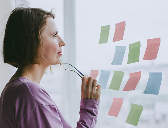 Woman standing in front of window reading post stuck to it
