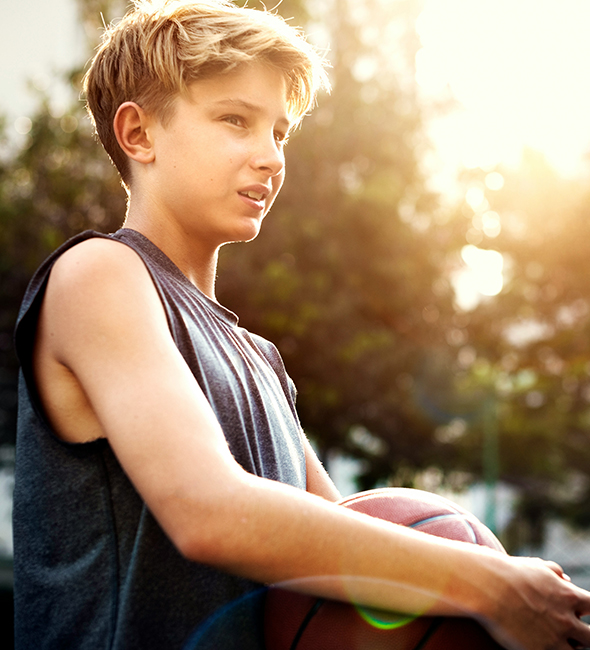 Boy holding basketball looking concerned